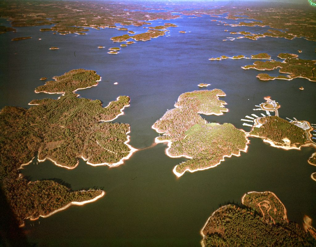 An aerial photo of Lake Sidney Lanier in 1961 shows the lake in its early stages of development. The lake was created by the completion of Buford Dam on the Chattahoochee River in 1956, and is also fed by the waters of the Chestatee River. The lake encompasses 38,000 acres (150 km2) or 59 sq mi (150 km2) of water, and 692 mi (1,114 km) of shoreline at normal level, a "full pool" of 1,071 ft (326 m) above mean sea level and the exact shoreline varies by resolution according to the coastline paradox. Named for poet Sidney Lanier, it was built and is operated by the U.S. Army Corps of Engineers for flood control and water supplies.

The 1961 aerial photo shows the lake in its early stages of development. The lake is surrounded by forests and farmland, and there are few signs of human development. The only major development visible in the photo is the Buford Dam, which is located at the southern end of the lake.

The 1961 aerial photo is a valuable historical document that shows the lake in its early stages of development. The photo is also a reminder of the natural beauty of the lake and its surroundings.